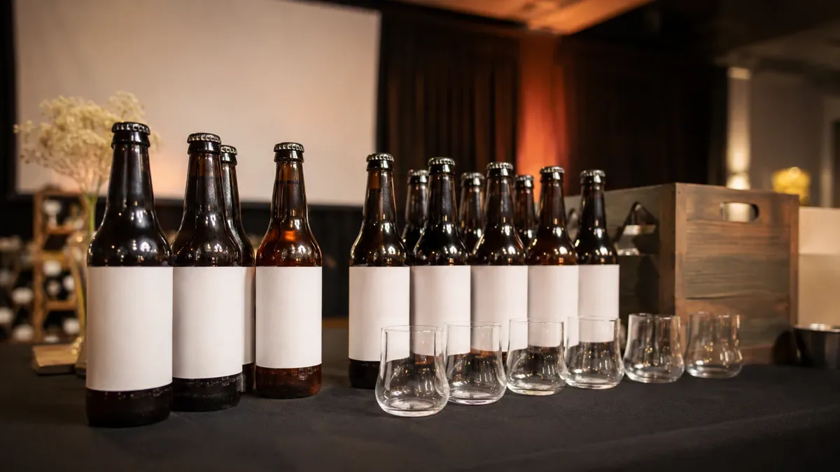 Mesa de presentación con botellas de cerveza artesanal y vasos de degustación, sin personas